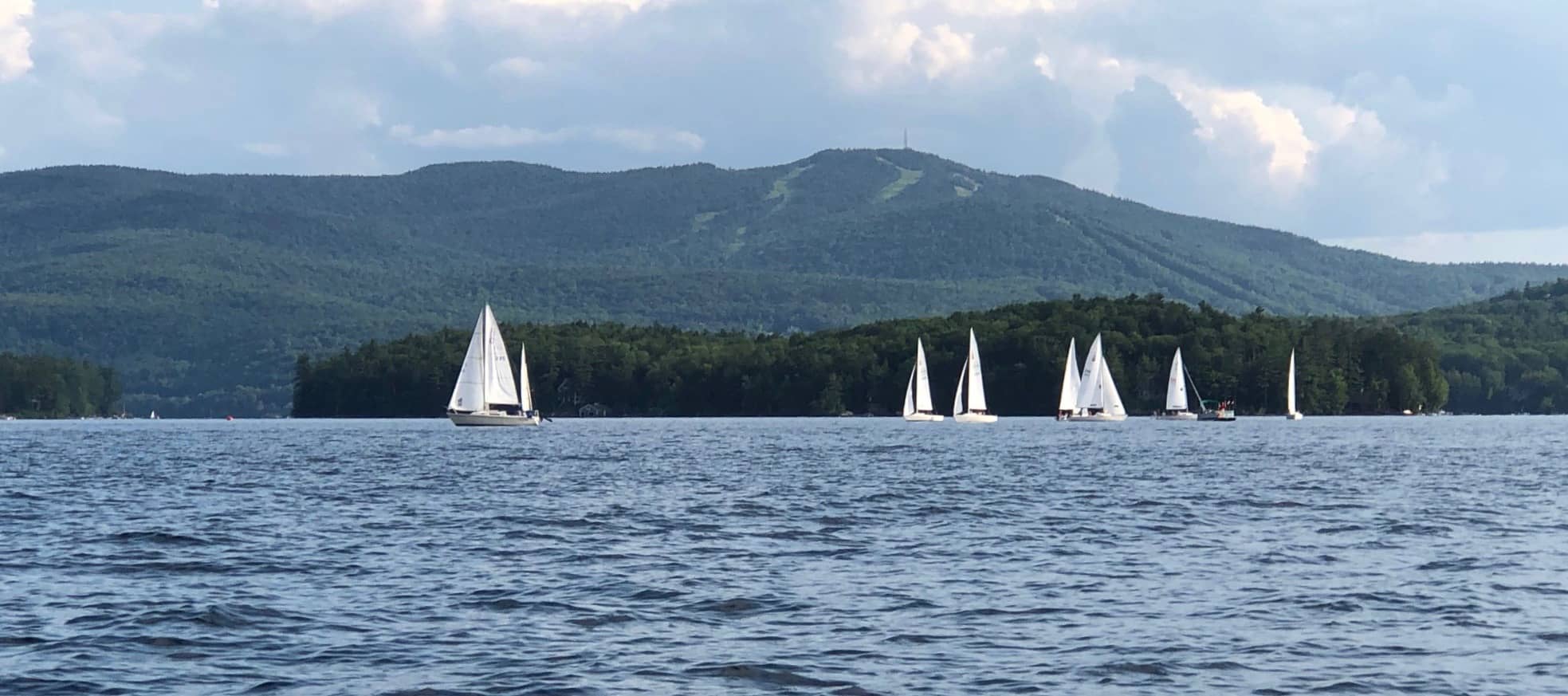 Sailboats racing against Sunapee Mountain